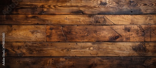 A detailed view of a wooden plank wall, showcasing the texture and grains of the wood. The natural pattern and rugged appearance of the planks provide a rustic backdrop.