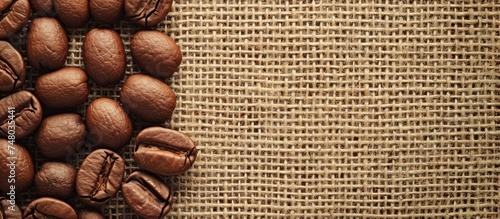 A collection of coffee beans arranged neatly on top of a wooden table. The beans are dark  glossy  and emit a rich aroma. They are the focus of the shot  with the tables texture providing a rustic