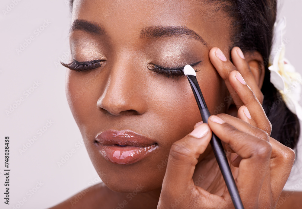 Black woman, face and brush for eyeshadow with beauty, makeup and lashes on grey background. Skin glow, hands and apply cosmetic product with tools for cosmetology, shimmer or glitter with shine Black woman, face and brush for eyeshadow with beauty, makeup and lashes on grey background. Skin glow, hands and apply cosmetic product with tools for cosmetology, shimmer or glitter with shine