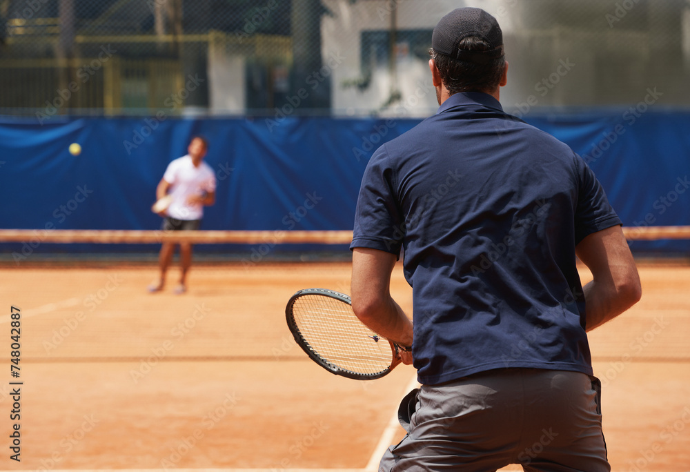 Fitness, sports and tennis with man on court for competition, game or match in summer from back. Coaching, exercise or training with athlete person and rival outdoor on clay for healthy hobby