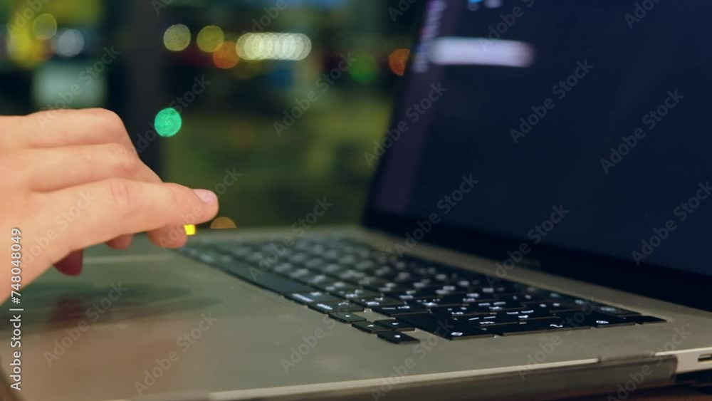 Hands of male typing on laptop sitting at night airport lounge. Blinking airport lights at background Hands of male typing on laptop sitting at night airport lounge. Blinking airport lights at background