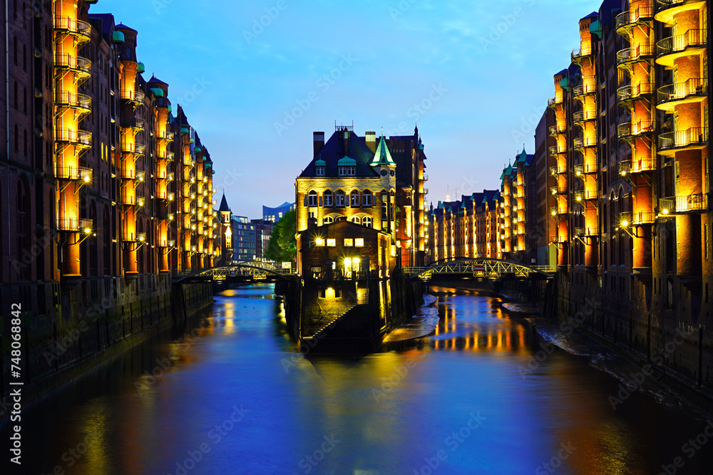 The Warehouse district Speicherstadt during twilight sunset in Hamburg, Germany. Illuminated warehouses in Hafencity quarter in Hamburg.
