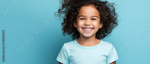 laughing child in blank t-shirt on an isolated blue solid background perfect photo for advertising, with empty copy space
