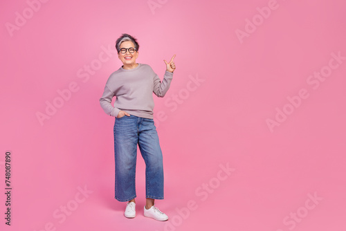 Full length photo of cheerful grandmother wear trendy clothes presents empty space proposition novelty isolated on pink color background
