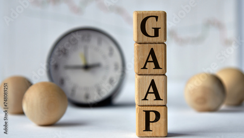 Foto GAAP - acronym on wooden cubes on graph, clock and wooden balls background
