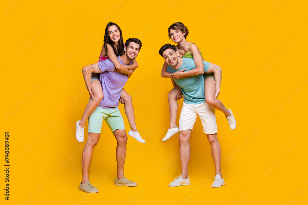 Obraz premium Full length photo of people rest relax guys piggyback girls isolated shine color background