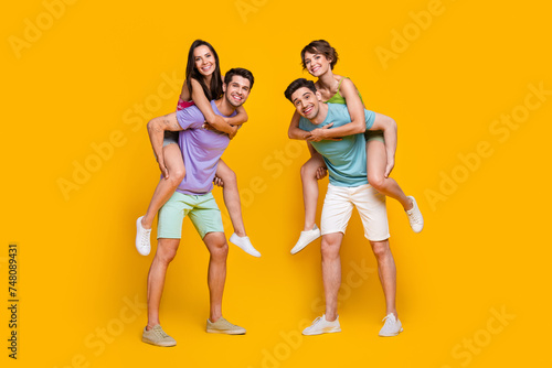 Full length photo of people rest relax guys piggyback girls isolated shine color background