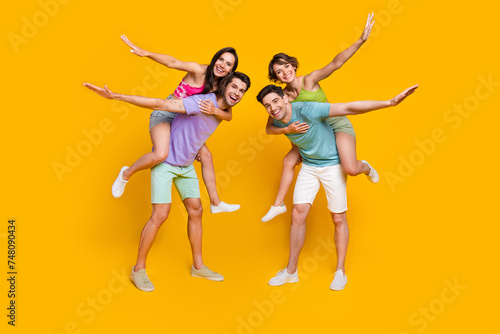 Full size photo of girls feel playful flying plane on piggyback guys isolated bright color background
