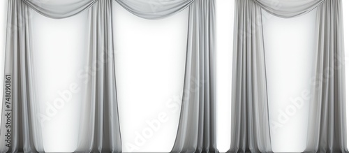 Three sheer curtains made of lightweight fabric are suspended from a rod on a wall. The curtains gently billow in the breeze, creating a soft and airy atmosphere in the room.