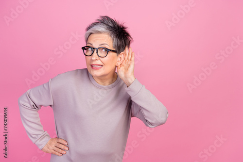 Closeup photo of pensioner grey haircut lady touch ear eavesdropping listen information empty space isolated on pink color background