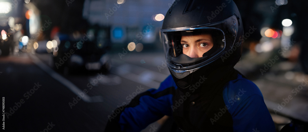 female motorcyclist close-up in a helmet in the evening on a motorcycle in the city. female motorcyclist close-up in a helmet in the evening on a motorcycle in the city.