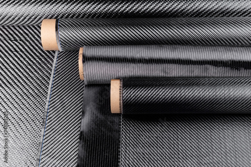 Rolls with various real woven carbon fiber enforcement raw material cloth. composite material industry high tech background.