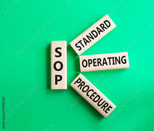 SOP - Standard Operating Procedure symbol. Wooden blocks with word SOP. Beautiful green background. Business and SOP concept. Copy space.