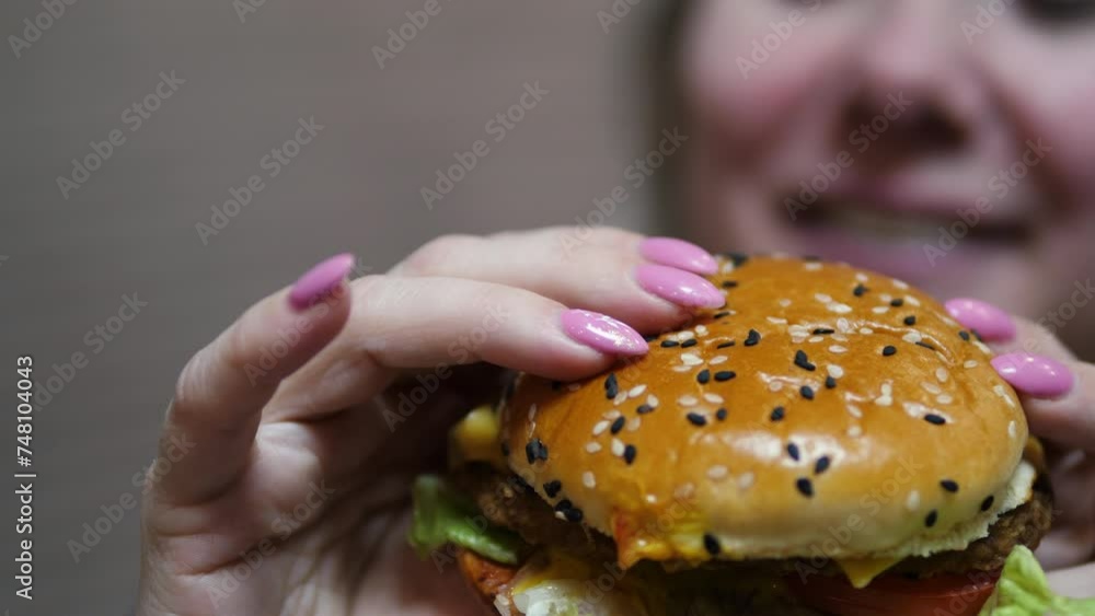 Tidbit, Cheeseburger in the arms of a smiling Caucasian woman whose face is out of focus. fast food concert, unhealthy diet Tidbit, Cheeseburger in the arms of a smiling Caucasian woman whose face is out of focus. fast food concert, unhealthy diet