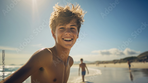 a teenage boy happily enjoying himself on a sunny beach during a warm day. teenage boy on the beach in the summer. travelling alone concept, happy moment