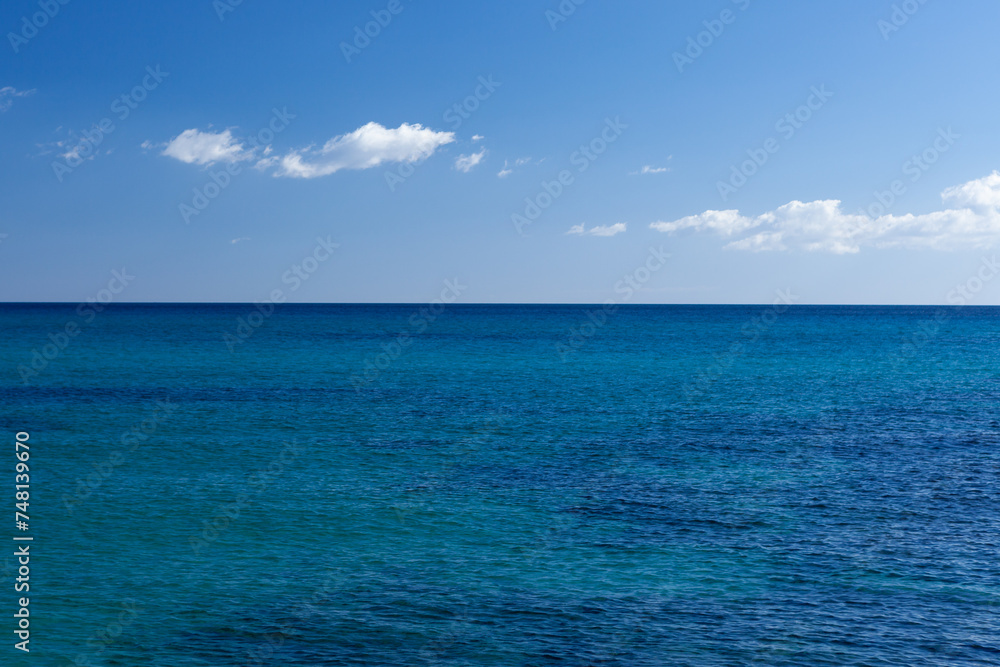 Clear and still blue turqoise water of Mediterranean sea with blue sky at Sardinia, Italy on sunny day. Beautiful sea view.