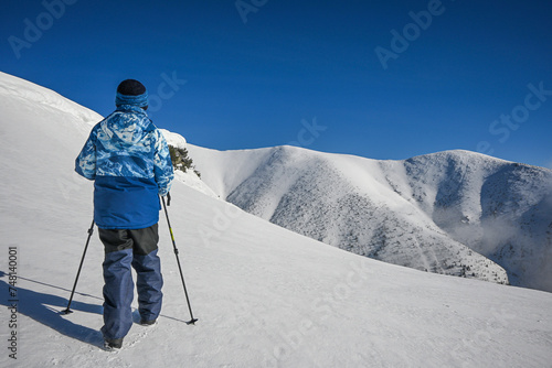 a little boy hiker walks along the snowy ridge of the Western Tatras to Baranec, beautiful view photo