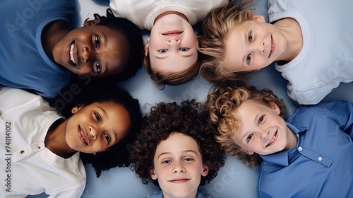 Diverse group of adorable children lying in a circle on the floor, smiling and creating a joyful, captured from above