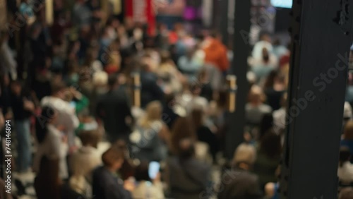 Blurred view captures young entrepreneurs networking in event. Scene shows vibrant startup culture, potential business incubator meeting. Ideal for themes of youth in entrepreneurship, startup dynamic