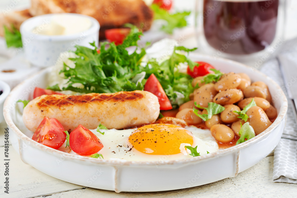 English breakfast. Keto breakfast. Fried egg, beans, chicken sausage and coffee cup. English breakfast. Keto breakfast. Fried egg, beans, chicken sausage and coffee cup.