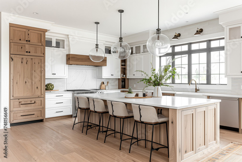 A beautiful farmhouse kitchen with white and white oak cabinets and chairs sitting at a large white oak island with a waterfall marble countertop.	 photo