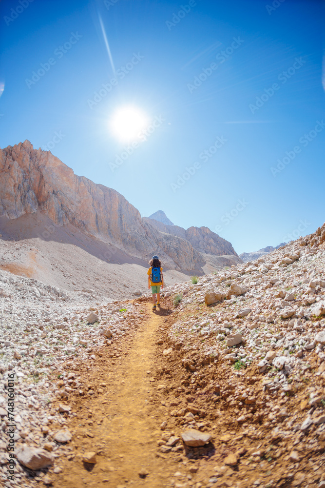 child travels in the mountains with a backpack. mountain hike in high mountains. Turkey.