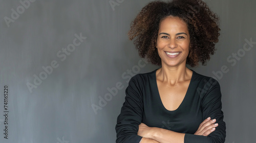 Retrato de empresária madura com os braços cruzados em pé contra um fundo cinza photo