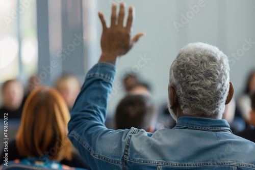Senior Man with Grey Hair Participating Actively by Raising Hand in a Seminar
