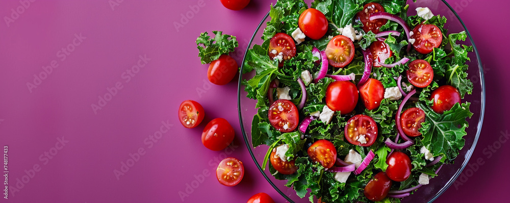 Crisp kale salad with cherry tomatoes and feta cheese on a modern glass plate against a deep purple background Top view space to copy.