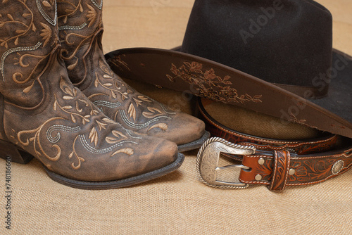 Obraz na płótnie embroidered brown boots, dark brown hat and belt with silver buckle - text space