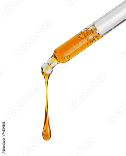 Stretched drop of a yellow oily liquid dripping from a pipette close up isolated on a white background