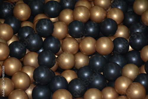 Golden black balls in a dry pool close up