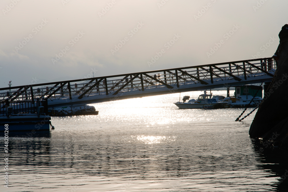 View of the footbridge at the riverside during sunset