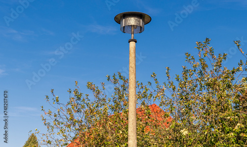 Old GDR street lamp in front of a blue sky