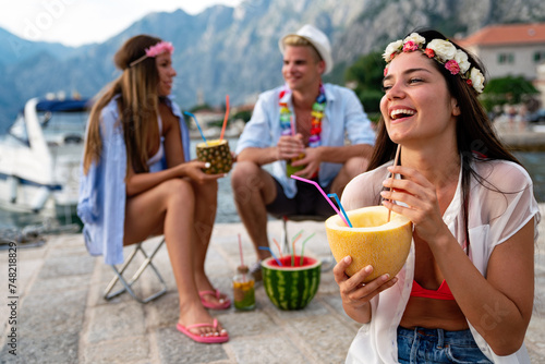 Group of multiethnic friends enjoying Hawaiian party on summer vacation.