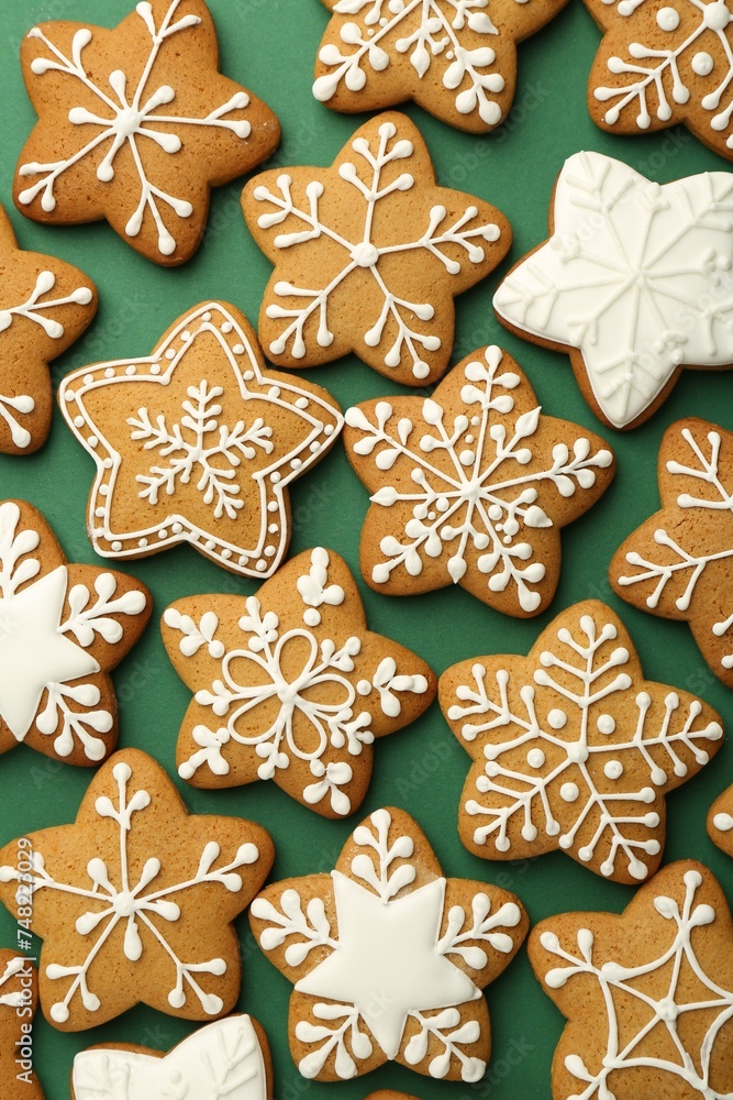 Tasty Christmas cookies with icing on green background, flat lay Tasty Christmas cookies with icing on green background, flat lay