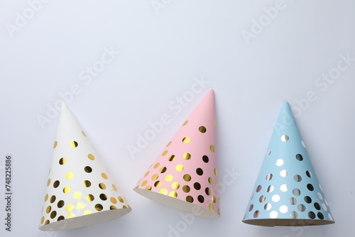 Beautiful party hats on light background, top view. Space for text