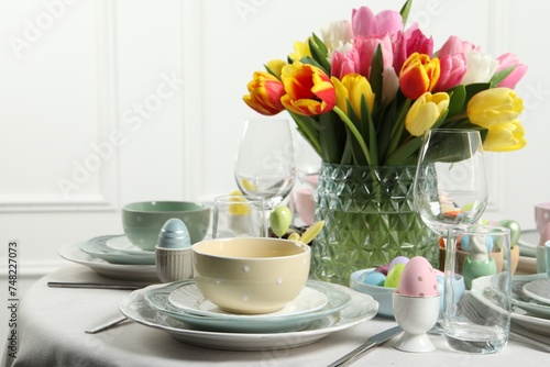 Fototapeta Naklejka Na Ścianę i Meble -  Easter celebration. Festive table setting with beautiful flowers and painted eggs
