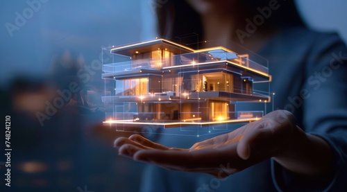 L'hologramme d'une maison d'habitation projeté au dessus d'une main d'une femme.