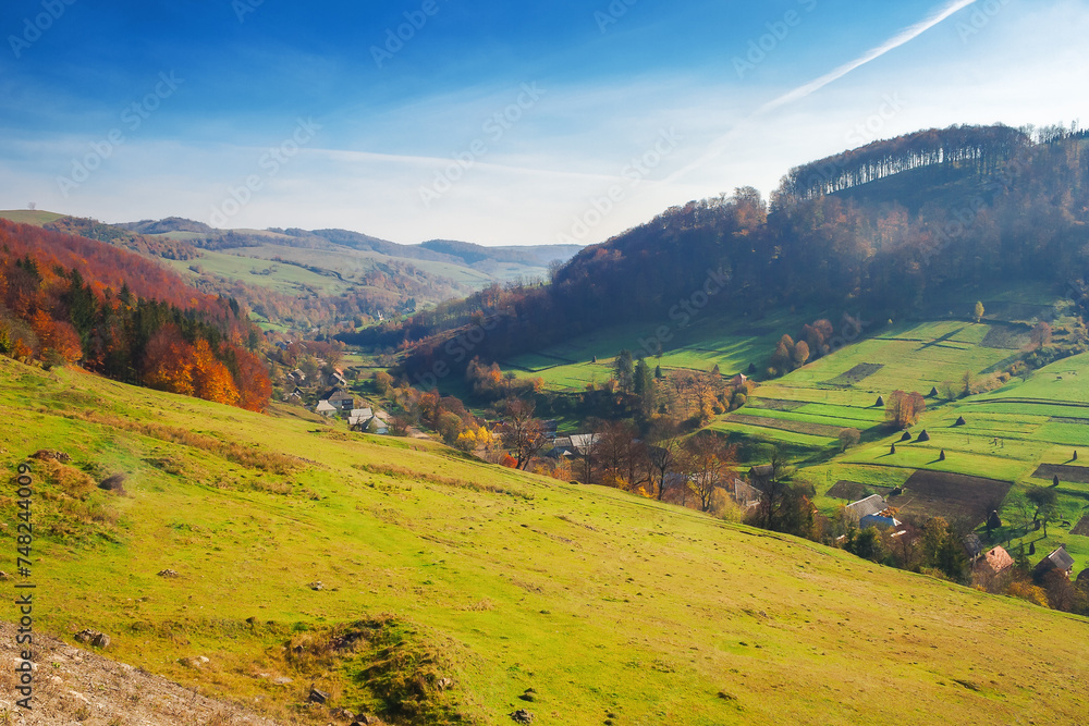 Obraz premium rural landscape of carpathian mountains. beautiful countryside scenery in autumn season with fields on the hills and village in the valley