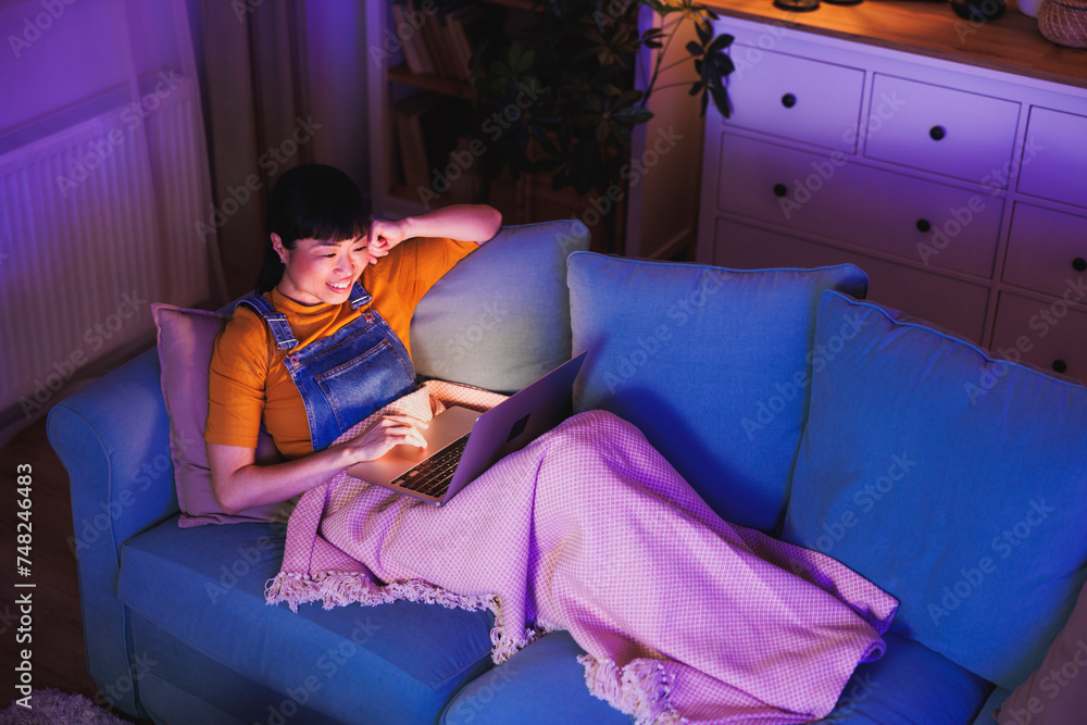 Obraz premium Mature Asian woman using laptop computer at home late at night
