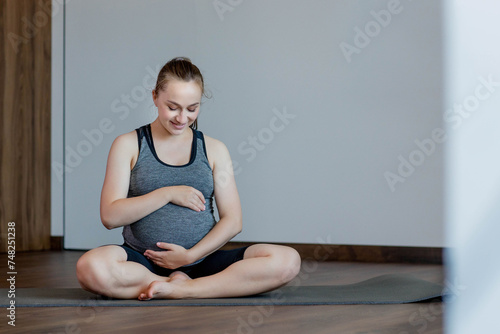 Happy beautiful pregnant woman before exercising at home © volody10