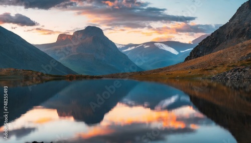 Mountain Majesty: Witness the Tranquil Beauty of a High Altitude Lake, Awash in the Gentle Glow of Dawn's First Light, Creating a Symphony of Reflection and Harmony. Generative AI © grahof_photo