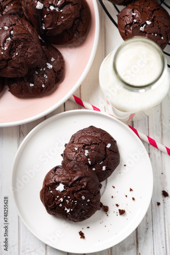 Delicious snack of brownie cookies with cracked top and sprinkled salt flakes and milk