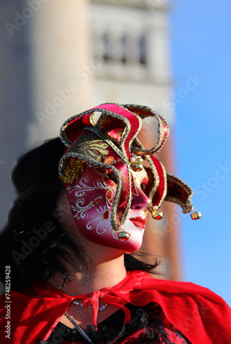 Masked person with decorated clothes and mask with unrecognizable face during the celebration of the Venice Carnival photo
