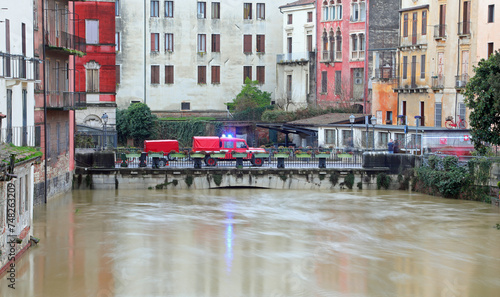 fire engines with flashing blue sirens is the river in the foothills that is overflowing during the flood