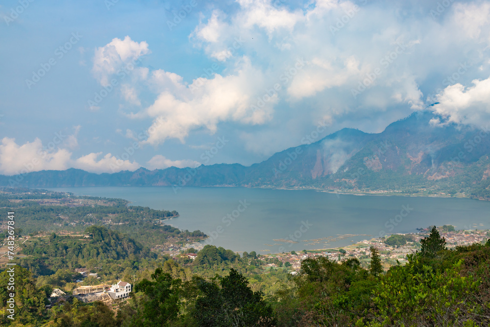 Naklejka premium Panoramic view of a lake Batur (Danau Batur) surrounded by mountain, tropical landscape with colorful clouds in the sky. Danau Batur, Gunung Batur, Kintamani, Bali, Indonesia.