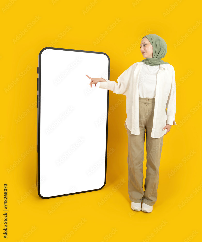 Touching huge display panel, full body view muslim woman wear hijab touching huge display panel. Using mobile application on big smartphone mock up. Advertising concept idea image, yellow background. Touching huge display panel, full body view muslim woman wear hijab touching huge display panel. Using mobile application on big smartphone mock up. Advertising concept idea image, yellow background.