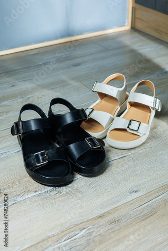 Women's leather sandals stand on the floor. Women's summer shoes.