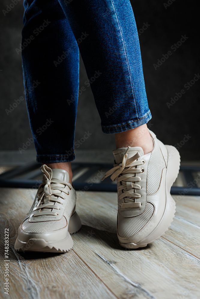 Beige women's sneakers. Collection of women's leather shoes. Female legs in leather beige casual sneakers. Stylish women's sneakers. Beige women's sneakers. Collection of women's leather shoes. Female legs in leather beige casual sneakers. Stylish women's sneakers.